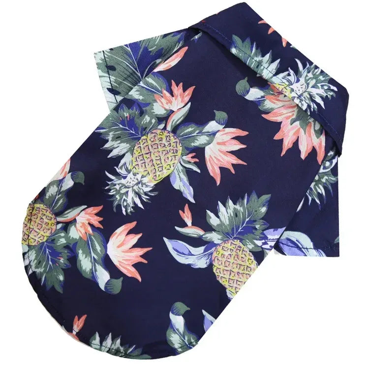 Chemise hawaïenne pour chien de couleur bleu foncé avec des motifs d'ananas et de fleurs tropicales.