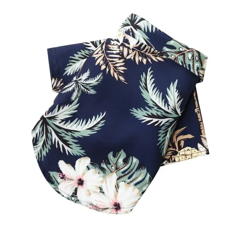 Chemise hawaïenne pour chien de couleur bleu marine avec des fleurs blanches et des feuilles vertes.