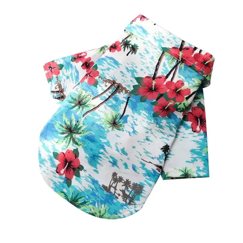 Chemise hawaïenne pour chien avec un motif tropical bleu et rouge, représentant des palmiers et des fleurs.