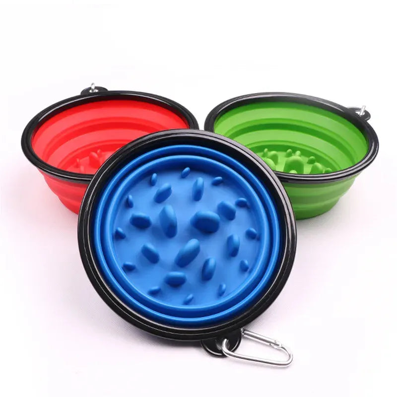 Trois gamelles pliantes pour chien en silicone, de couleur bleu, rouge et vert, avec des motifs en relief pour ralentir la prise de nourriture.